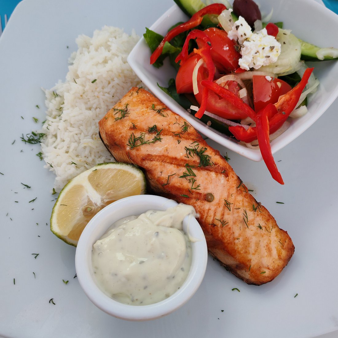 Grilled salmon, rice and village salad served at Doma